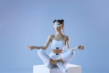 A woman in a white outfit and blindfold meditating on a pedestal.